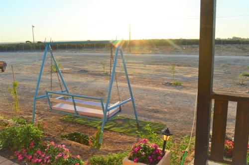 a swing in a yard with a parking lot at צימר מול השקיעה in Retamim