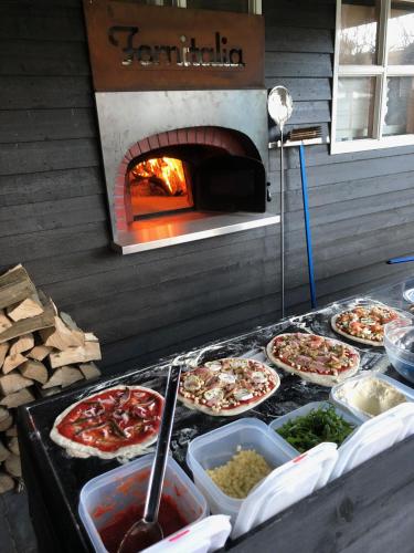 a group of pizzas on a counter with a pizza oven at B&B Mir Lo in Mierlo Adults only in Mierlo