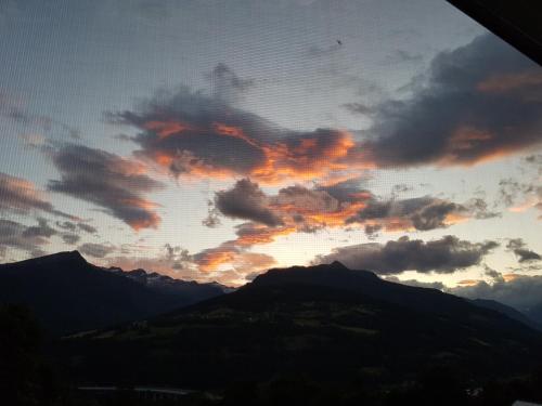 a sunset with clouds in the sky over mountains at Ferienhaus Sonnenstrahl in Gmünd in Kärnten