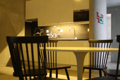 a kitchen with a table and chairs and a sink at N1 Hostel Apartments and Suites in Santarém