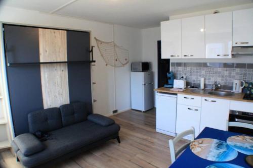un salon avec un canapé et une cuisine dans l'établissement Welcome Calais - Le Cottage de la Côte d'Opale, à Calais