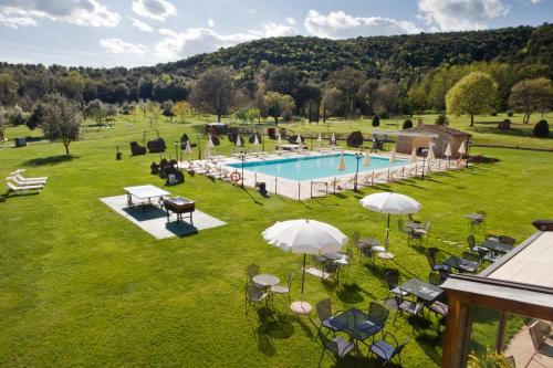 einen Blick über einen Pool mit Sonnenschirmen in der Unterkunft Hotel & Restaurant Casolare Le Terre Rosse in San Gimignano
