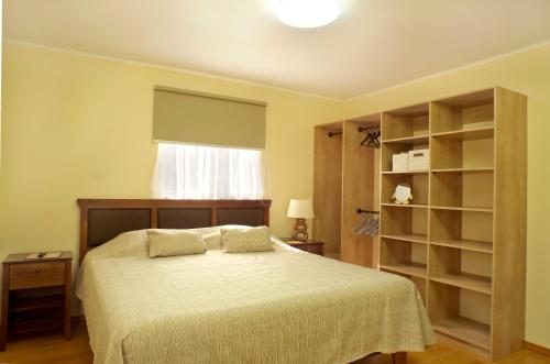 a bedroom with a bed and a window and shelves at Moderna Casa Nueva - Bahía Inglesa in Bahia Inglesa