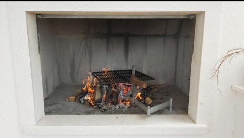 uma lareira com um fogo dentro dela em Villa Pergola -Apartment Roko em Mlini