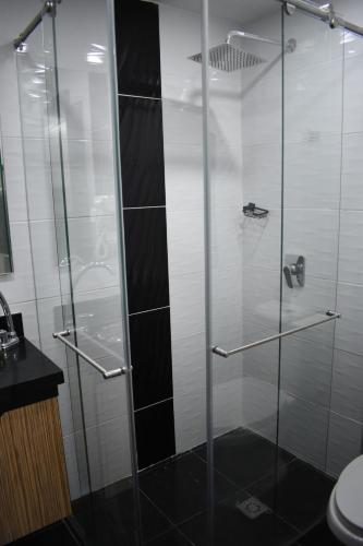 a shower with a glass door in a bathroom at Hostel Boutique Nido de Loros in Medellín