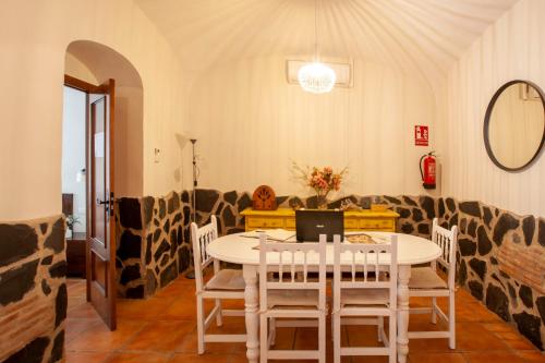 a dining room with a table and a laptop on it at Casa Rural La Salamandrija- con piscina, patio y barbacoa in Cordobilla de Lácara