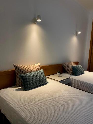 um quarto com duas camas com almofadas em Parra Holidays Q House na Guia