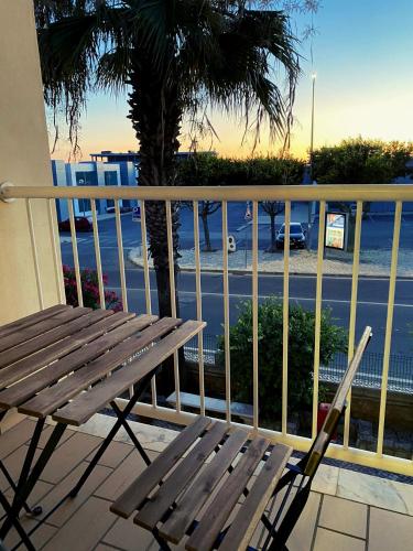 um banco de madeira sentado numa varanda com vista para uma rua em Parra Holidays Q House na Guia