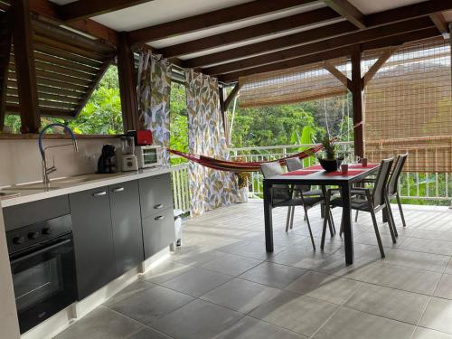 a kitchen with a table and chairs on a patio at La Fée amazonienne in Rivière-Pilote