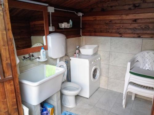 a bathroom with a toilet sink and a washing machine at Residenza butterfly IUN R6379 in Villasimius