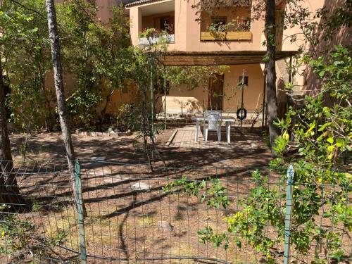 a fence in front of a house with a chair at Arboria Sun & Sea in Sorso
