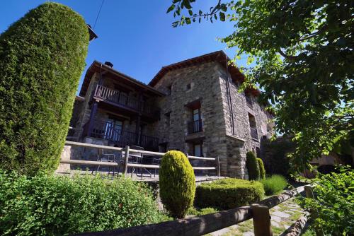 an old stone house with bushes in front of it at Gra de fajol in Girona