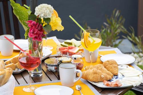 a table with food and glasses of wine and flowers at Abraços dos Avós - Casas de aldeia in Viana do Castelo