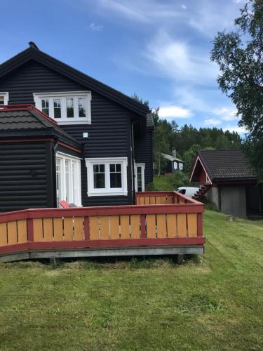 a house with a large deck in the yard at Villa Solsiden Geilo in Geilo