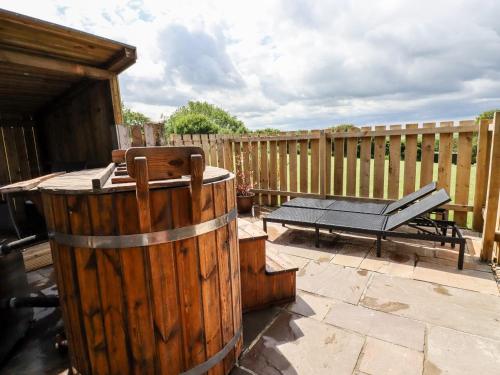 a patio with a table and a wooden fence at Bramble in Wadebridge