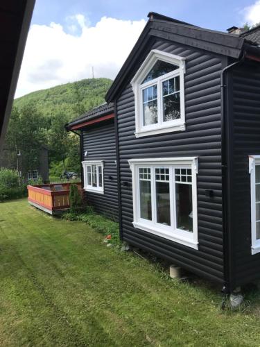 a black house with white windows and a yard at Villa Solsiden Geilo in Geilo
