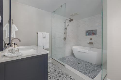 a white bathroom with a tub and a sink at Ocean House in Newport