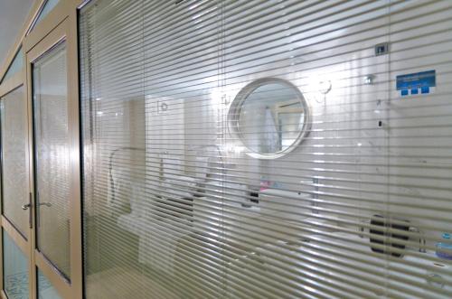 a glass wall with a mirror in a bathroom at Habitat Hotel in Kilkís