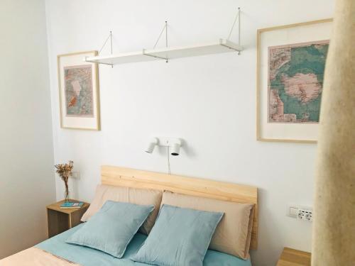 a bedroom with a bed with two blue pillows at Apartamento The Wall Xperience in León
