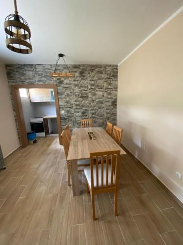 a dining room with a wooden table and chairs at Zicka plaza in Kraljevo