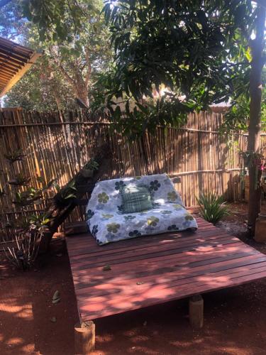 a bench with a pillow on it in a garden at Vila Flores Pousada in Serra do Cipo