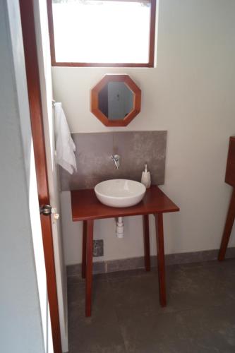 a bathroom with a sink and a mirror on a table at Indano Art Lodge in Lamas