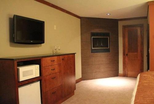 ein Schlafzimmer mit einer Mikrowelle und einem TV an der Wand in der Unterkunft Avalon Lodge South Lake Tahoe in South Lake Tahoe