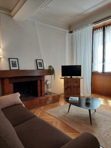 un salon avec un canapé et une télévision à écran plat dans l'établissement Le Vintage - appartement en plein coeur de la Vieille Ville, à Annecy