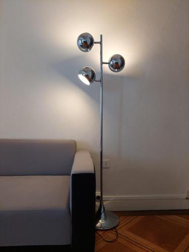 une lampe assise à côté d'un lit dans une pièce dans l'établissement Le Vintage - appartement en plein coeur de la Vieille Ville, à Annecy