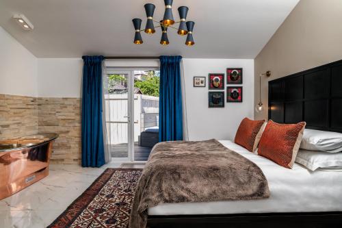 1 dormitorio con 1 cama grande y cortinas azules en Relax in Super Size Copper Tub - 2 bedroom villa en Inverness