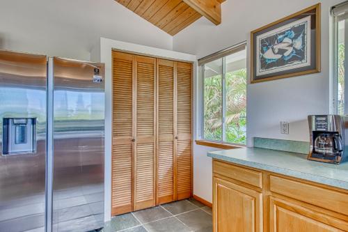 a kitchen with a refrigerator and a window at Kona Kanewa Home in Kailua-Kona