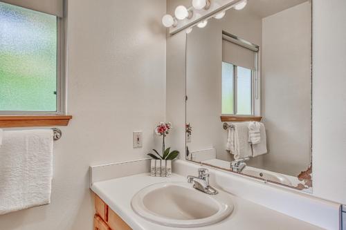a white bathroom with a sink and a mirror at Kona Kanewa Home in Kailua-Kona