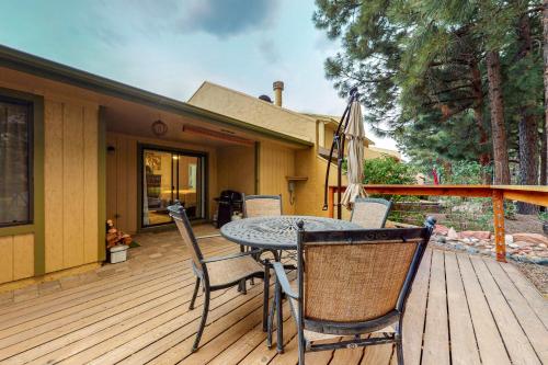 a patio with a table and chairs on a deck at Cozy Mountain Townhome in Flagstaff