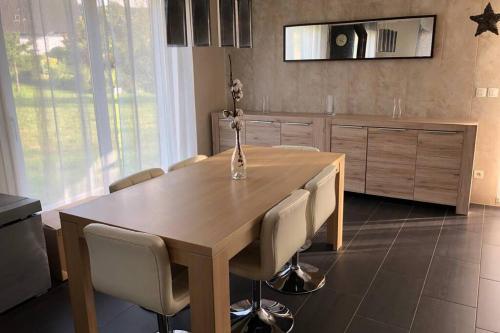 a kitchen with a wooden table and chairs at Havre de paix dans le Jura Alsacien avec piscine privée externe de mai à septembre in Bendorf