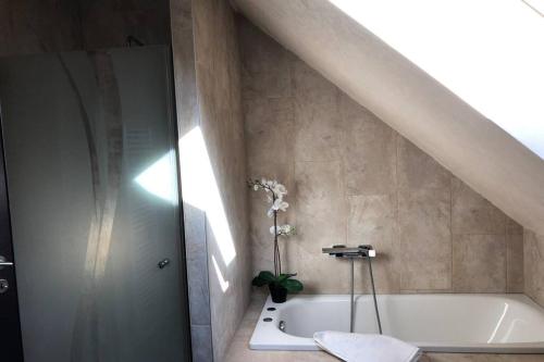 a bathroom with a white bath tub and a sink at Havre de paix dans le Jura Alsacien avec piscine privée externe de mai à septembre in Bendorf