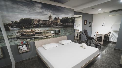 1 dormitorio con 1 cama y una pintura de un río en Paris Motel, en Matão