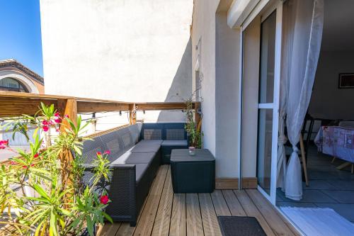 a balcony with a couch and a table on a building at Appartement Domloc in Carcassonne