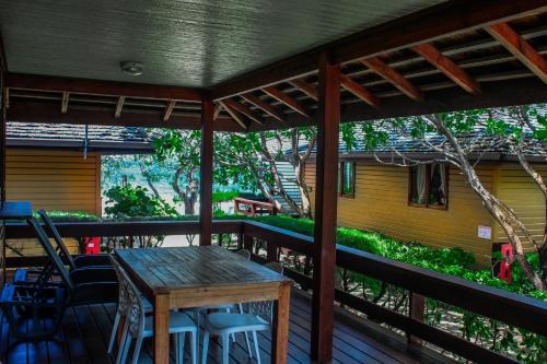 une table et des chaises en bois sur une terrasse en bois dans l'établissement Moorea Golf Lodge, à Maharepa