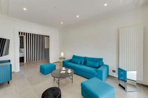 a living room with a blue couch and a table at Swan Lake - Design apartment facing Lake Annecy in Annecy