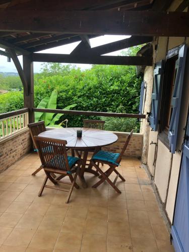 un patio avec une table et des chaises sur un balcon dans l'établissement Maisonnette quercynoise, à Bétaille