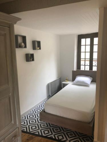 une chambre avec un lit blanc et une fenêtre dans l'établissement Maisonnette quercynoise, à Bétaille