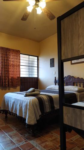 a bedroom with two beds and a ceiling fan at Posada Los Chaneques Catemaco in Catemaco
