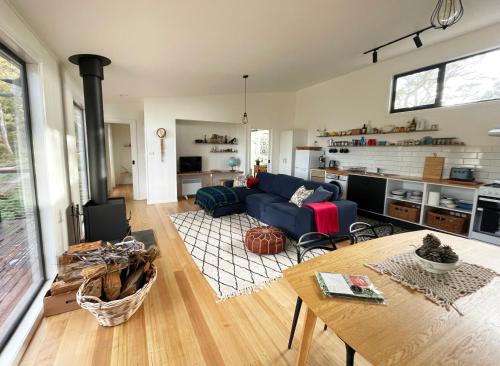 a living room with a blue couch and a table at Casita Rica in Glendevie