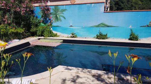 a swimming pool with a painting on the side of a house at Appart indépendant, 1 lit deux personnes et 1 appoint Piscine Jardin Direct Gare Aéroport et jardin in Toulouse