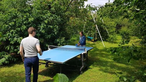 a man and a woman standing around a ping pong table at Appart indépendant, 1 lit deux personnes et 1 appoint Piscine Jardin Direct Gare Aéroport et jardin in Toulouse