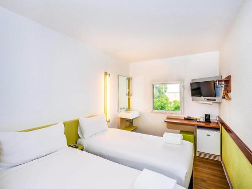 a hotel room with two beds and a television at ibis Budget - St Peters in Sydney
