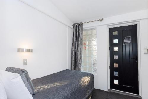 a bedroom with a bed and a window at The Tauranga on the Waterfront in Tauranga