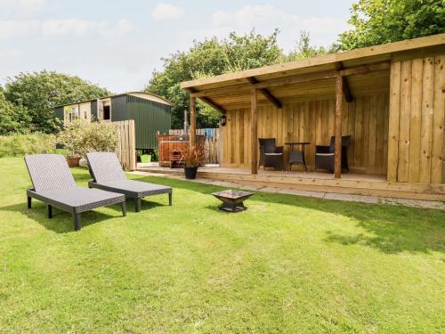 a backyard with two chairs and a gazebo at Willow in Wadebridge