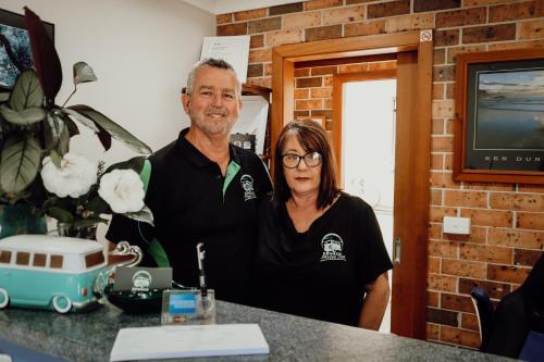 a man and a woman standing at a counter at Denman Motor Inn in Denman