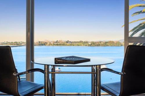 a table and two chairs with a view of the water at The Tauranga on the Waterfront in Tauranga